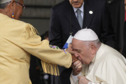 Pope Francis kisses hand of Canadian Indigenous woman as he arrives at Edmonton's International airport, Canada, Sunday, July 24, 2022.